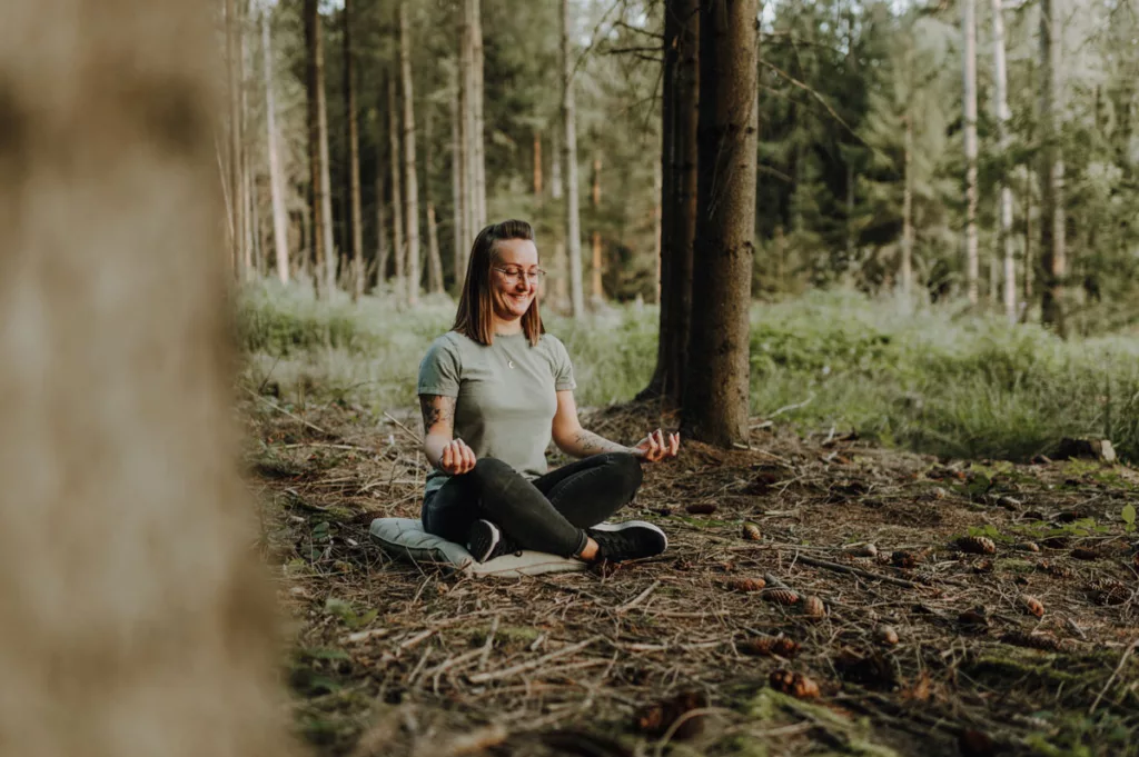Frau meditiert im Wald